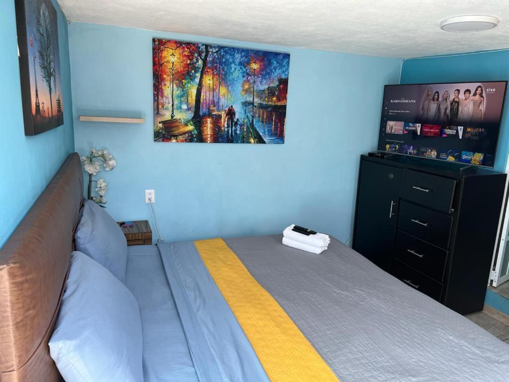 a bedroom with a bed and a painting on the wall at Estancia María Bonita Morelia in Morelia