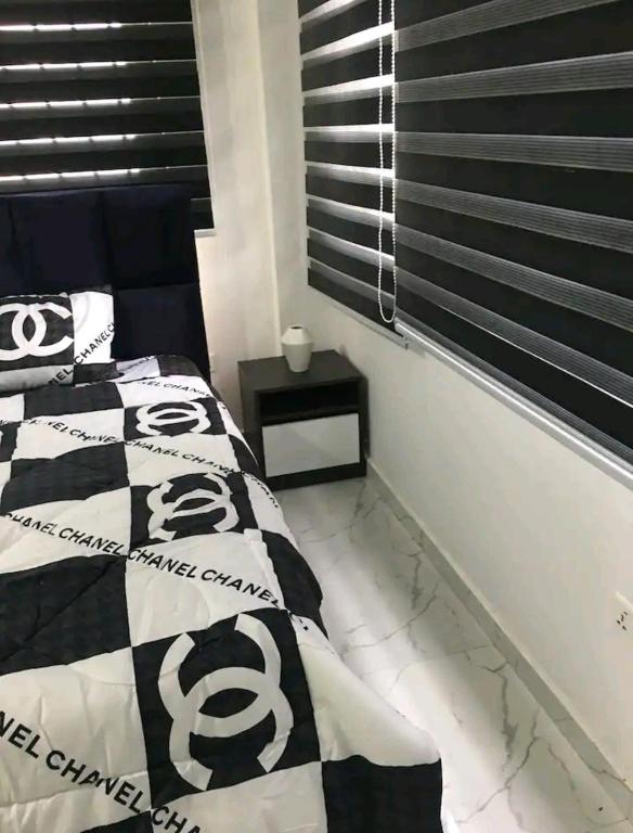a bedroom with a bed with a black and white comforter at Ajay's residence in Hanya