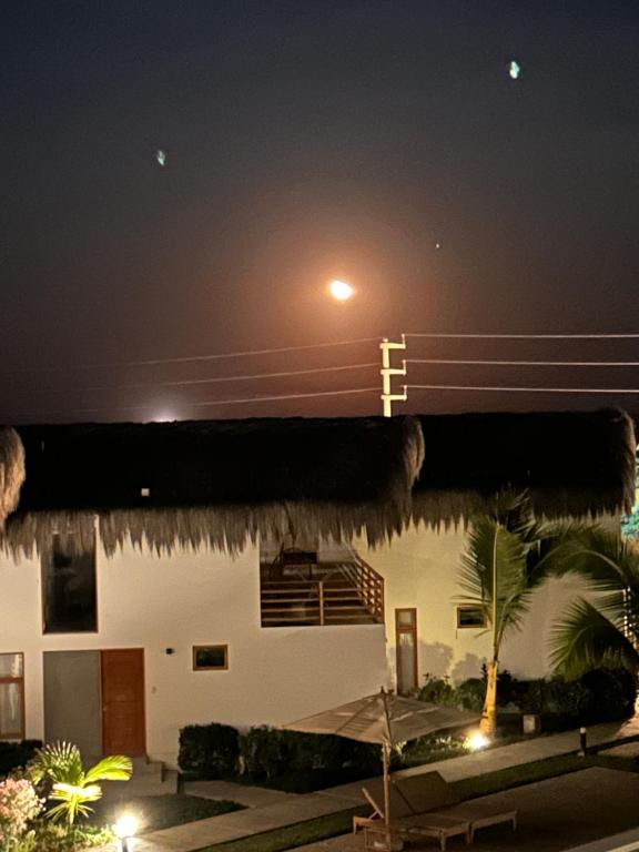 un edificio con una luz de la calle delante de él por la noche en VICHAYITO INN, en Chicama