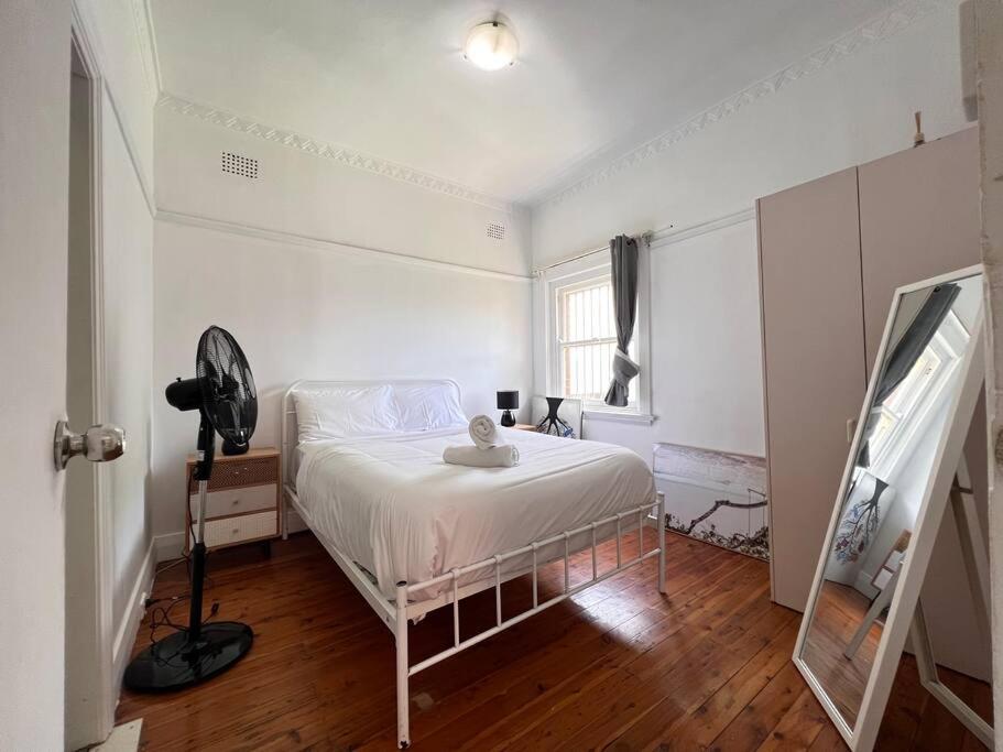 Cozy1 Bedroom Unit Near Maroubra Beach في سيدني: غرفة نوم بيضاء بها سرير ونافذة