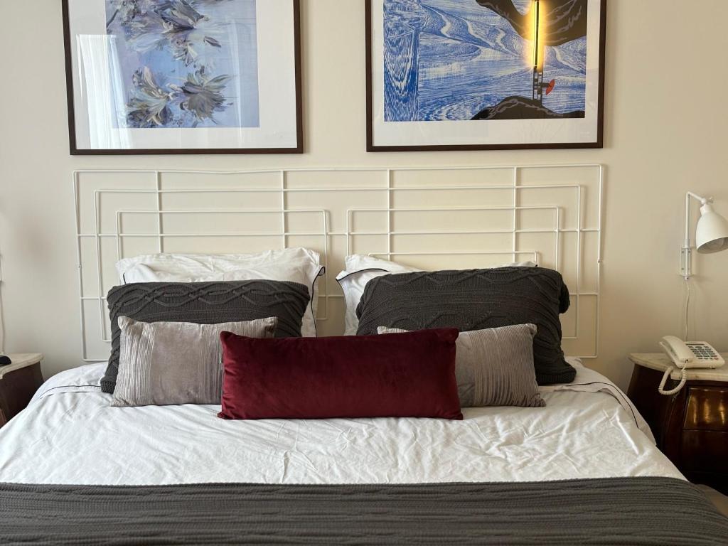 a bed with two pillows and two pictures on the wall at Flat no Itaim in São Paulo