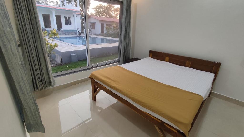 un piccolo letto in una camera con finestra di Mohor Retreat a Alibag