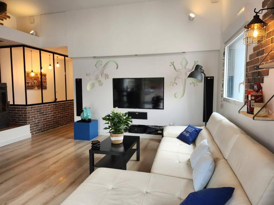 - un salon avec un canapé blanc et une télévision dans l'établissement Maison Vue Mer, à Pornichet