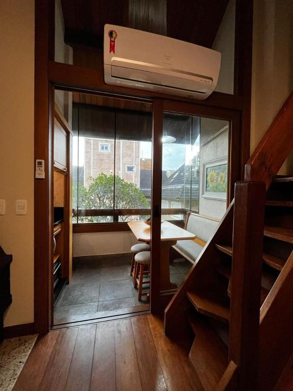 Habitación con mesa y comedor con ventana en Duplex 406 GrupoGLGramado, en Gramado