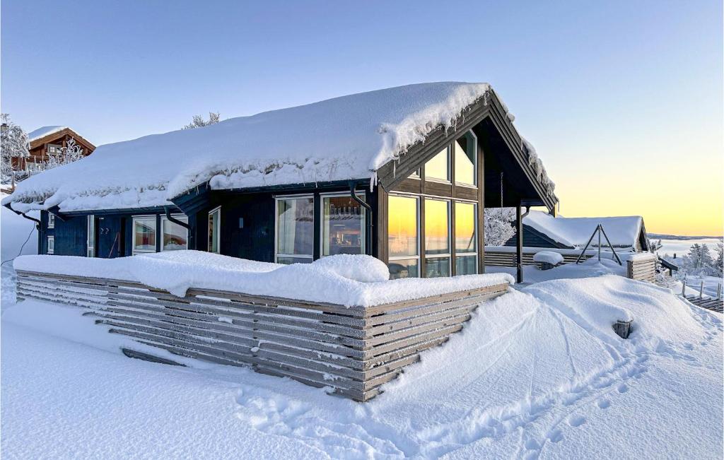 a house covered in snow with a pile of snow at Awesome Home In Etnedal With House A Mountain View in Etnedal