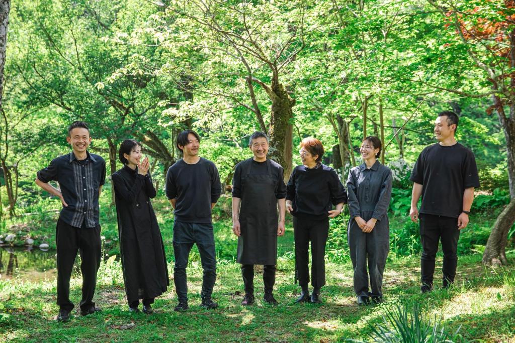 un grupo de personas de pie en la hierba en Shiroyamakan, en Shirakawa