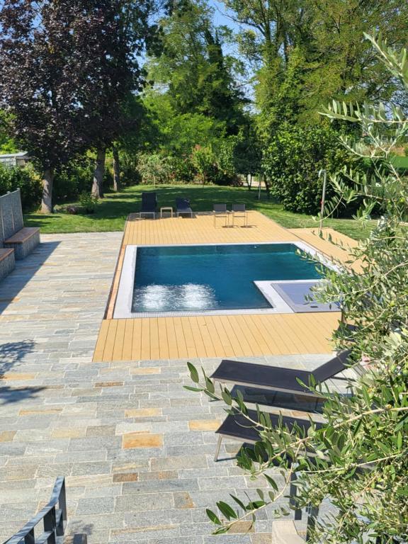 帕爾馬的住宿－Royal Suite Parma con Piscine Calda e Fredda，庭院内的游泳池,配有桌椅