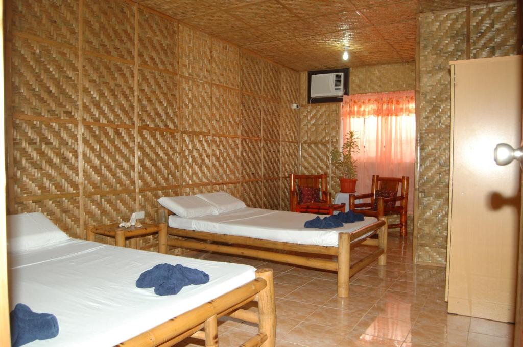 a room with two beds and a table and chairs at CasaKeja Inn in Panglao Island