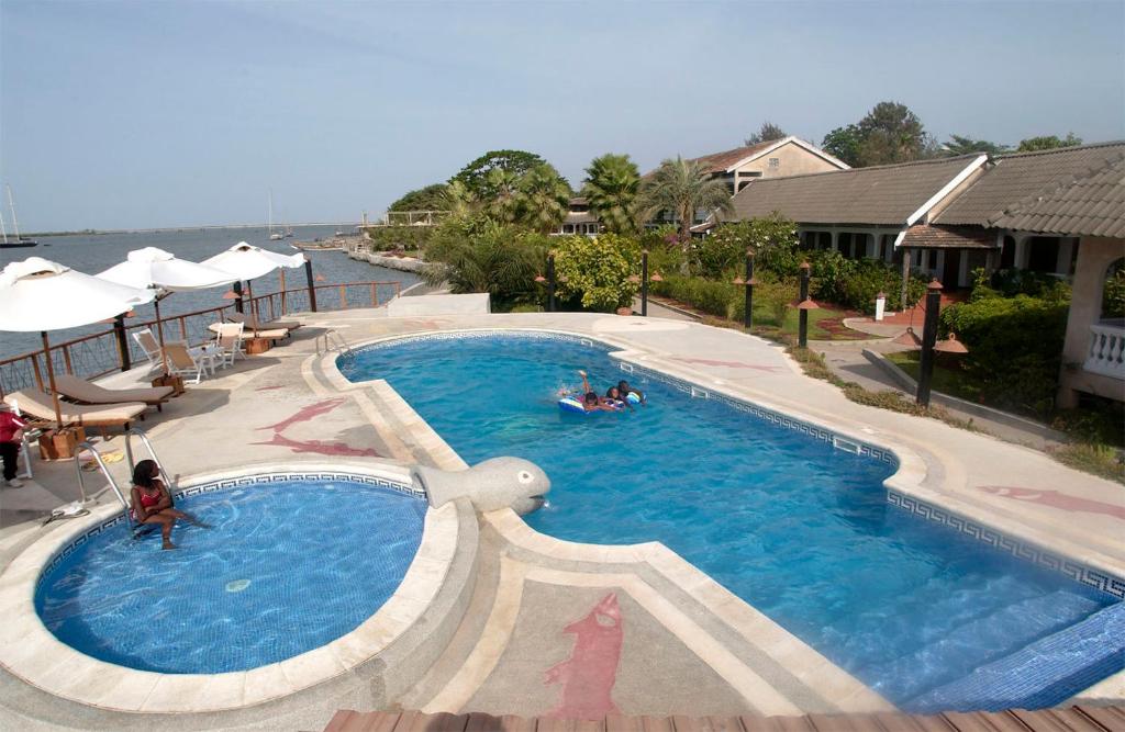 a large swimming pool with people in the water at Hôtel Kadiandoumagne in Ziguinchor