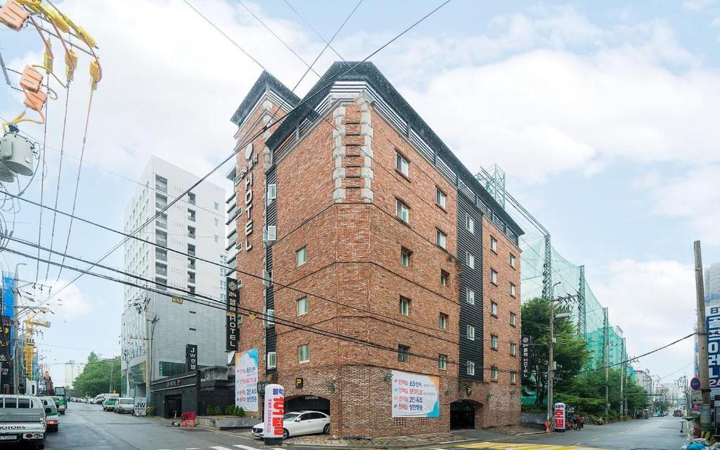 wysoki ceglany budynek przy ulicy miejskiej w obiekcie 24 Block Hotel w mieście Suwon