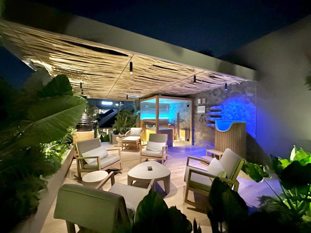 a patio with chairs and tables at night at Sin Nombre Bali - Sauna, Ice Bath & Roof Terrace in Canggu
