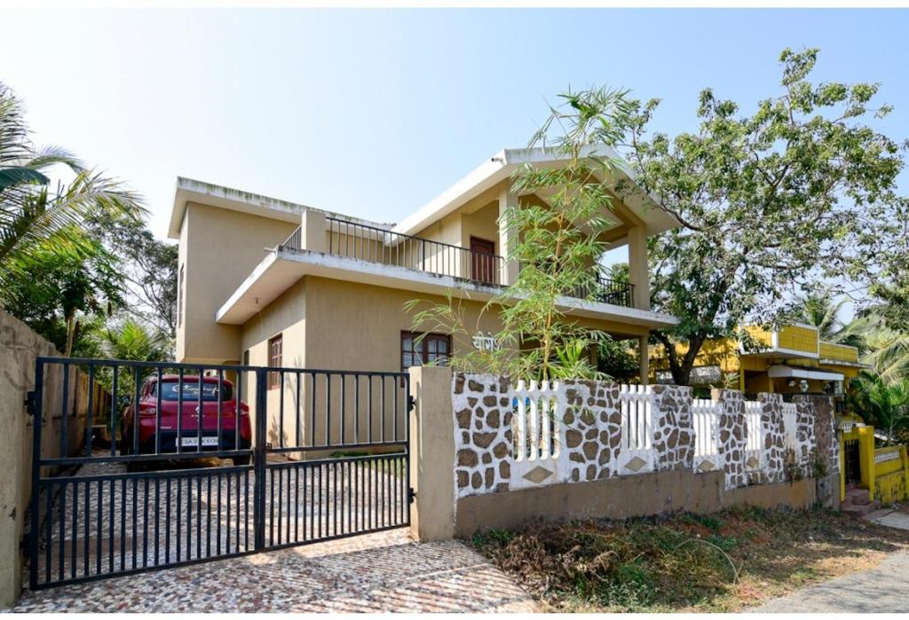 une maison avec une clôture devant elle dans l'établissement YOGESH VILLA, à Vieux-Goa