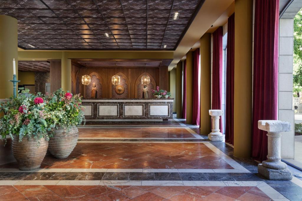 einen Altar in einem Gebäude mit zwei großen Vasen mit Blumen in der Unterkunft Hotel Palacio de Santa Paula, Autograph Collection in Granada