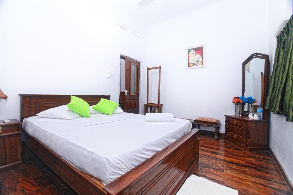 a bedroom with a large bed with green pillows at rockwood vila in Kandy