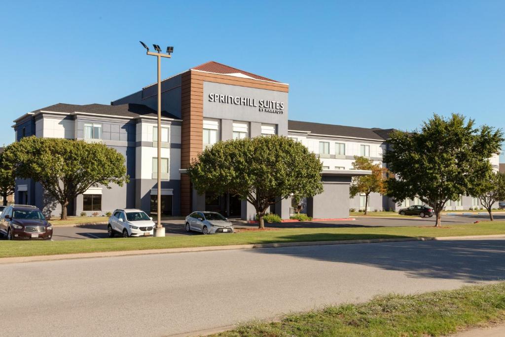 un bâtiment avec des voitures garées dans un parking dans l'établissement SpringHill Suites by Marriott Tulsa, à Tulsa