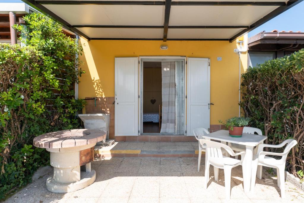 een patio met een tafel en stoelen voor een huis bij Monolocale ingresso indipendente con corte esclusiva in Montemarciano