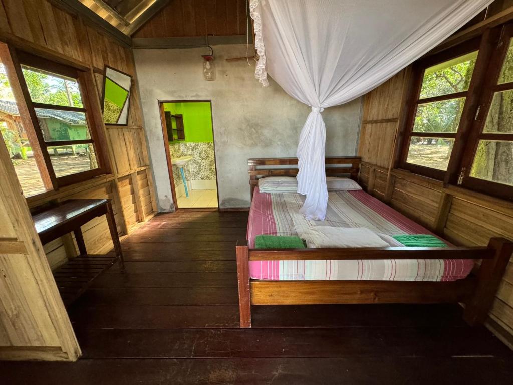 1 dormitorio con 1 cama en una habitación con ventanas en Changthong Bungalow en Koh Chang Ranong