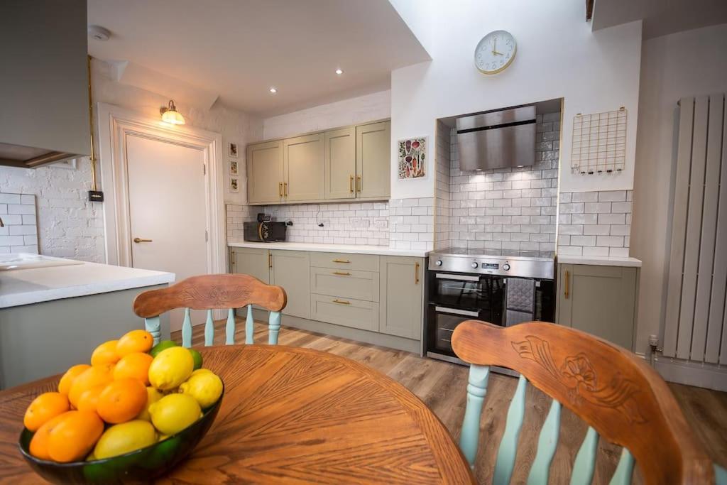 a kitchen with a table with a bowl of fruit on it at 4-bed botanical retreat in Plymouth