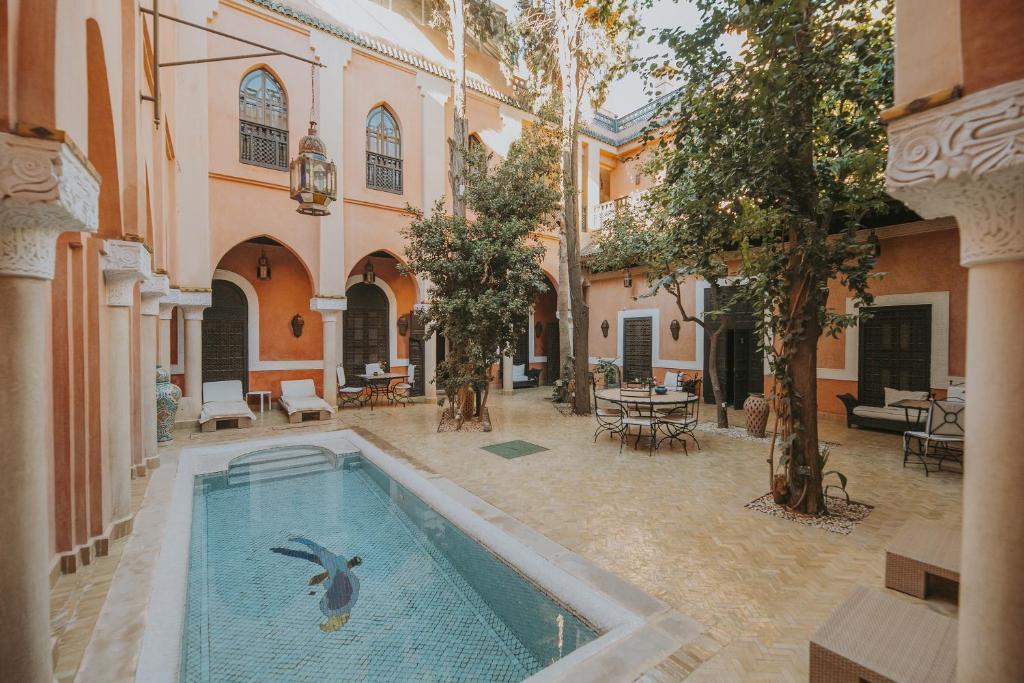 uma piscina num pátio com um pássaro na água em Riad Le Perroquet Bleu Suites & Spa em Marrakech