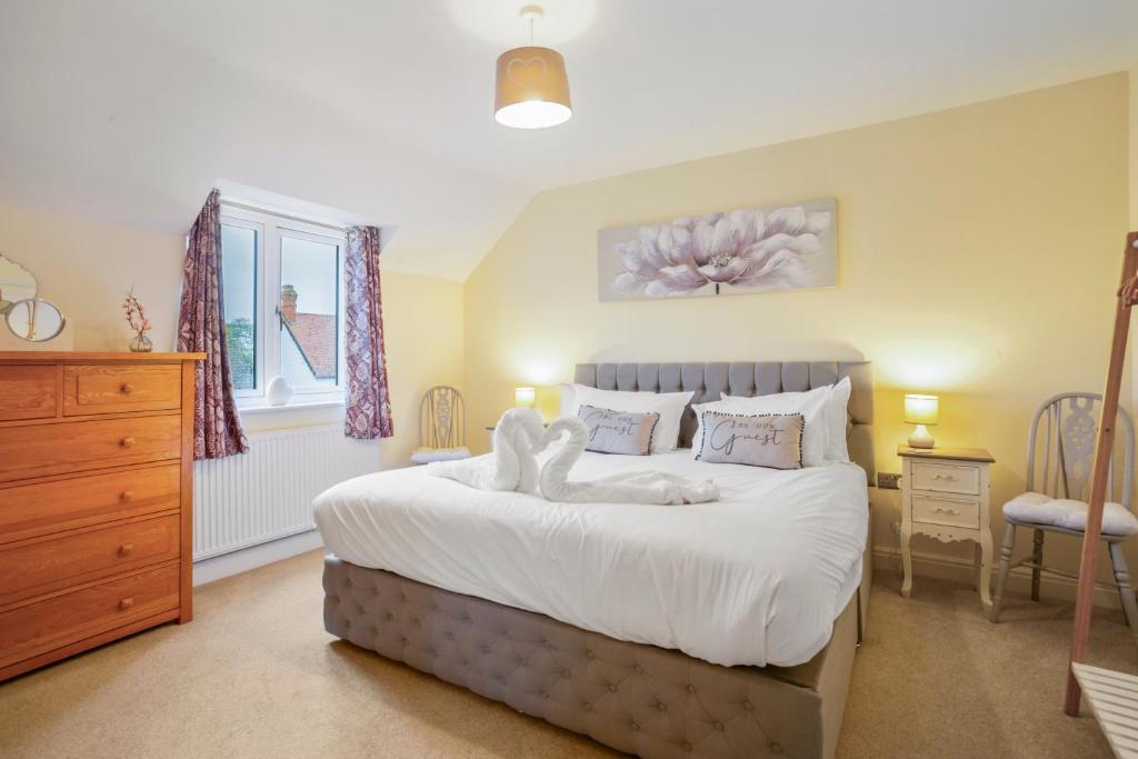 a bedroom with a bed with two teddy bears on it at Staddlestone Mews in Broadway