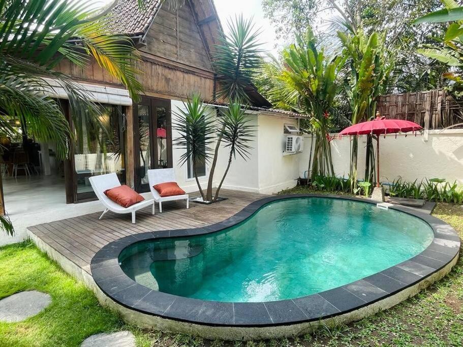 a swimming pool in the yard of a house at villa kayu keluarga lilas in Ubud