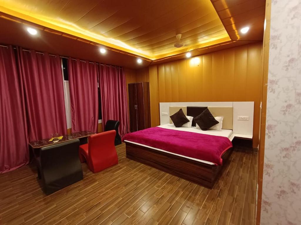 een slaapkamer met een bed en een rode stoel bij hotel pine view in Dagshai