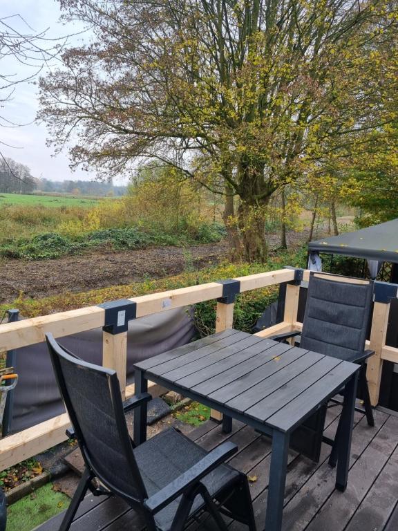 un tavolo da picnic con sedie su una terrazza in legno di Tiny Home mit Panoramaterrasse - Ausblick ins Grüne inklusive a Wilhelmshaven