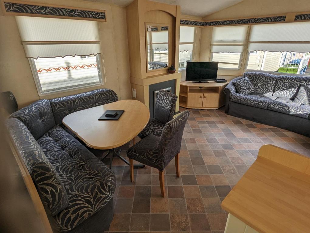 a living room with a table and a couch at Caravan in Kinmel Bay
