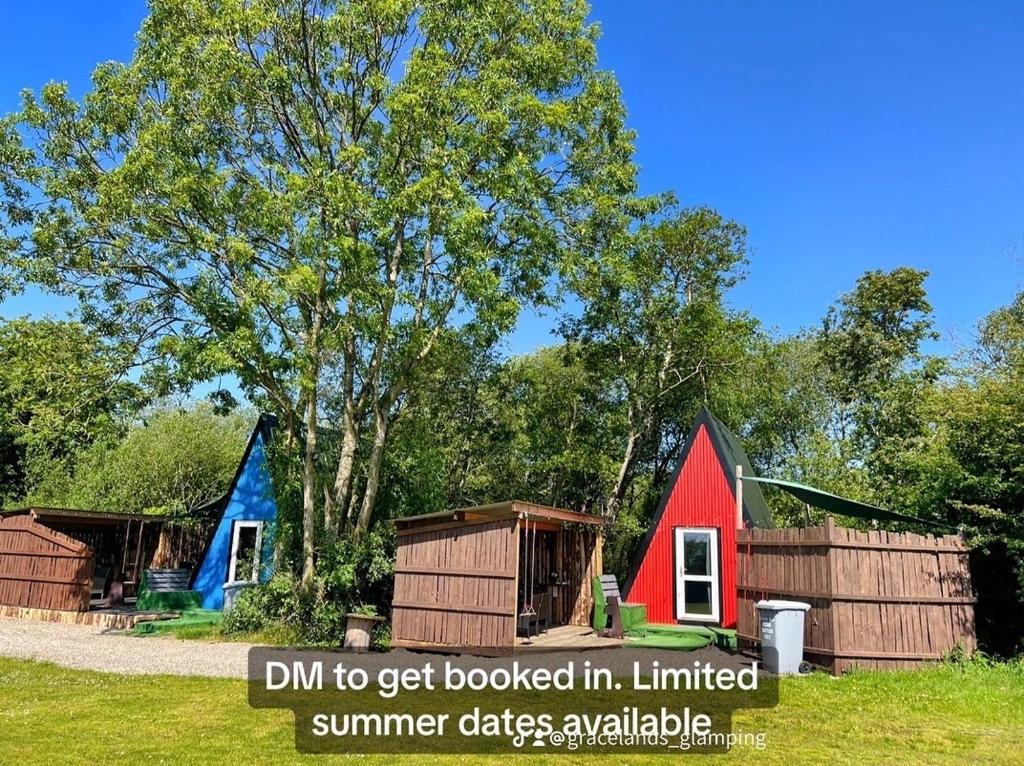 a group of small houses with the words dhm to get boomed ininstalled at Gracelands Glamping in Ballyronan