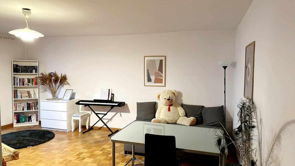 un orsacchiotto seduto su un divano in soggiorno di SilverSky Apartment a Varsavia