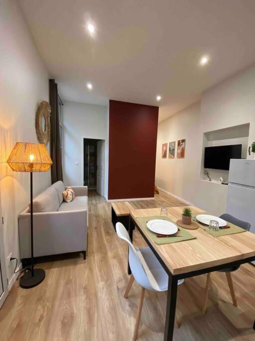 sala de estar con mesa y sofá en Logement entier-Clim-100%équipé-Hypercentre-Balcon, en Brive-la-Gaillarde