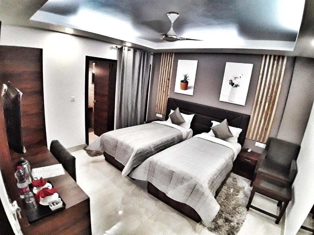 a bedroom with two beds and a chair in it at Airport Hotel Delhi Aerocity, Near Yashobhoomi in New Delhi