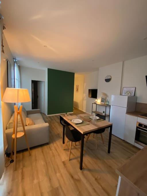 sala de estar con mesa y sofá en Appartement hypercentre 100% équipé *Clim*, en Brive-la-Gaillarde