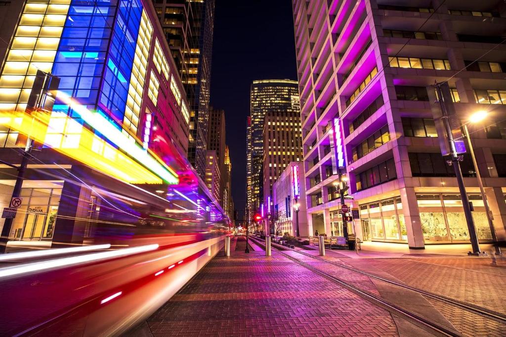 uma rua da cidade à noite com edifícios e carros em Urban Oasis Your Perfect Getaway in the Heart of Downtown! em Houston