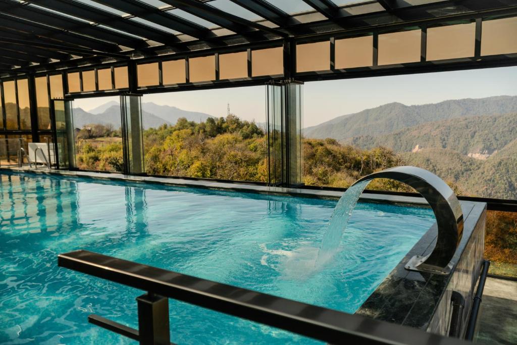 a swimming pool with a view of the mountains at Chateau Milisi in Batumi