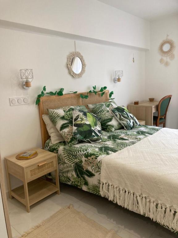 - une chambre dotée d'un lit avec un couvre-lit vert et blanc dans l'établissement L'escale chic gare Saint Charles, à Marseille