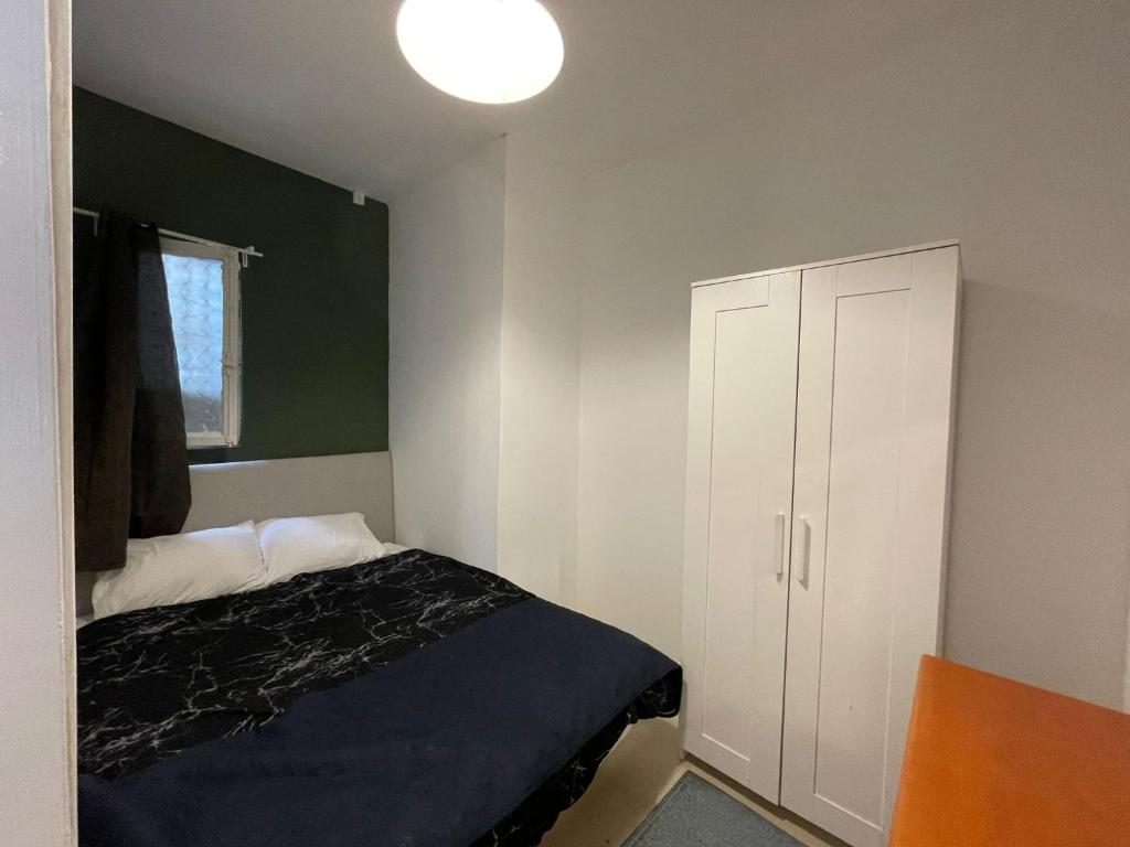 a bedroom with a bed and a white cabinet at עלמה in Tel Aviv