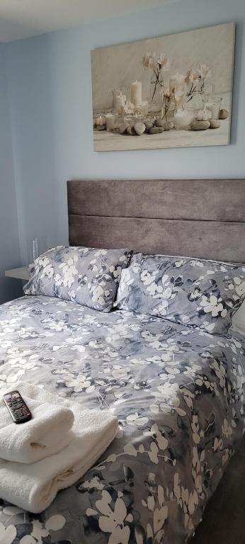 a bed with a comforter on it with at Nina's Den @ 26 Davidson Place in Newtown Saint Boswells