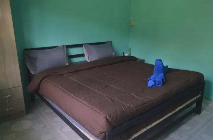 a large bed in a bedroom with a blue wall at The Lion House in Khlaung Phai Bae