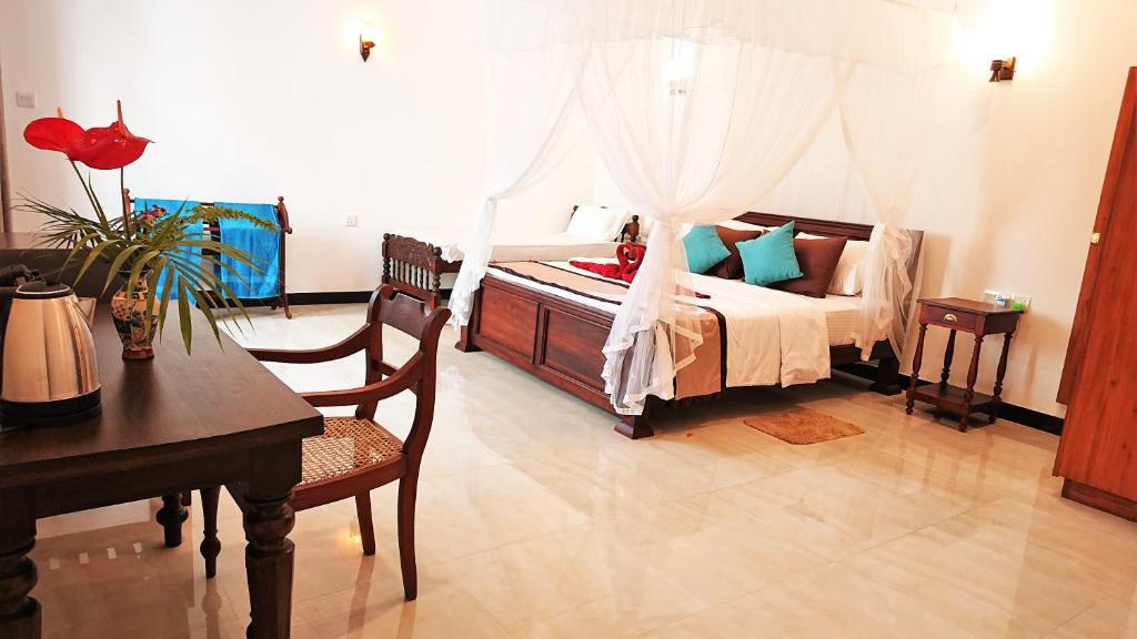 1 dormitorio con 1 cama con mesa y escritorio en Tropical Inn, en Mirissa