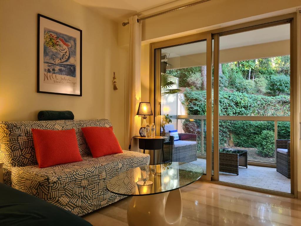 un salon avec un canapé et une table en verre dans l'établissement Studio grande terrasse à 5 min de la mer, à Nice
