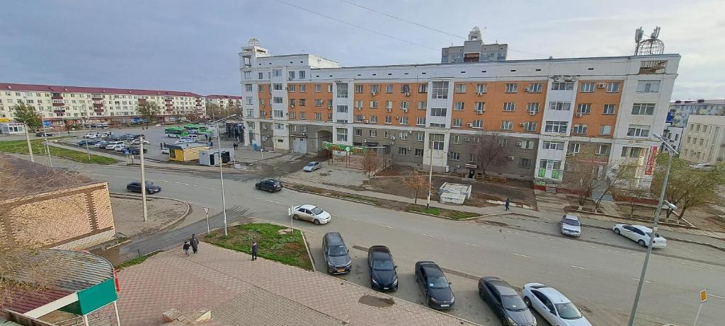 a city street with cars parked in a parking lot at Sweet Home 2 in Atyrau