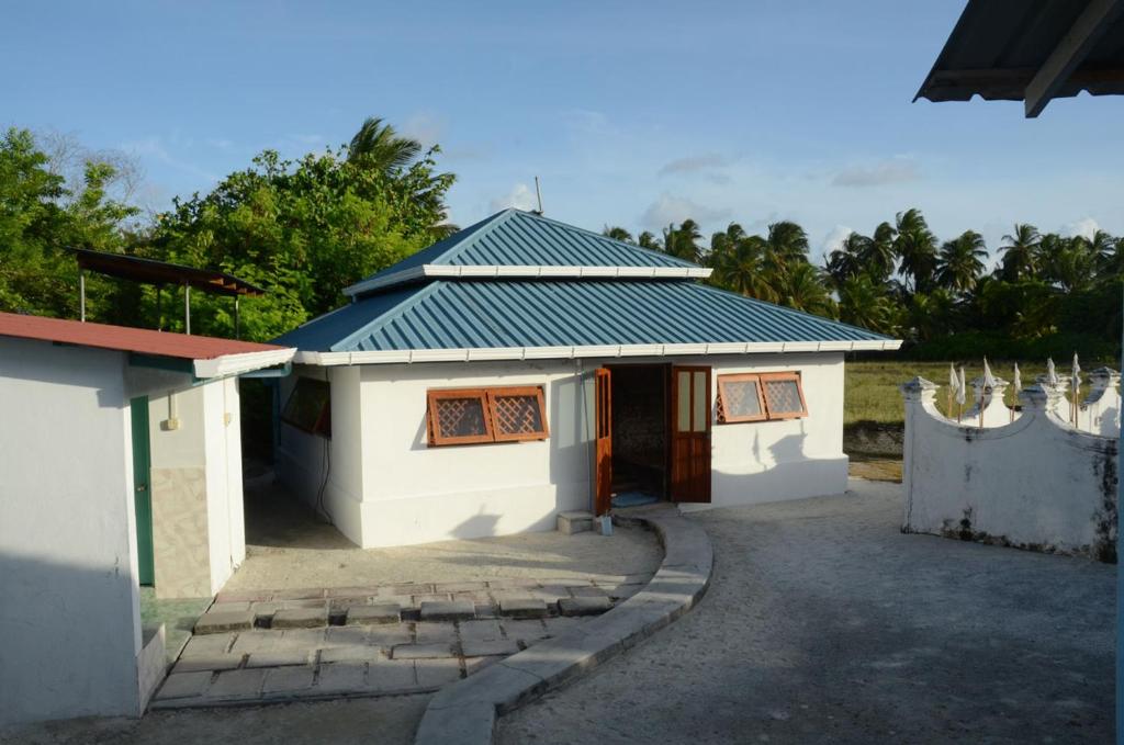 mały biały budynek z dachem w obiekcie MINNAIY w mieście Guraidhoo