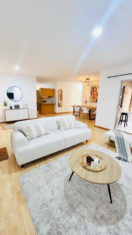 a living room with a white couch and a table at Luxury Modern Home in Summerstrand