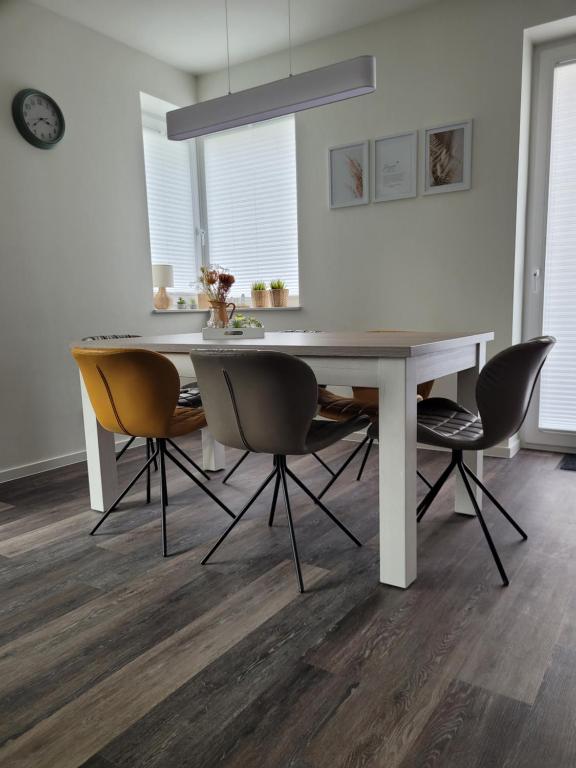 een eetkamer met een witte tafel en stoelen bij Nordseehus-HYGGE in Butjadingen