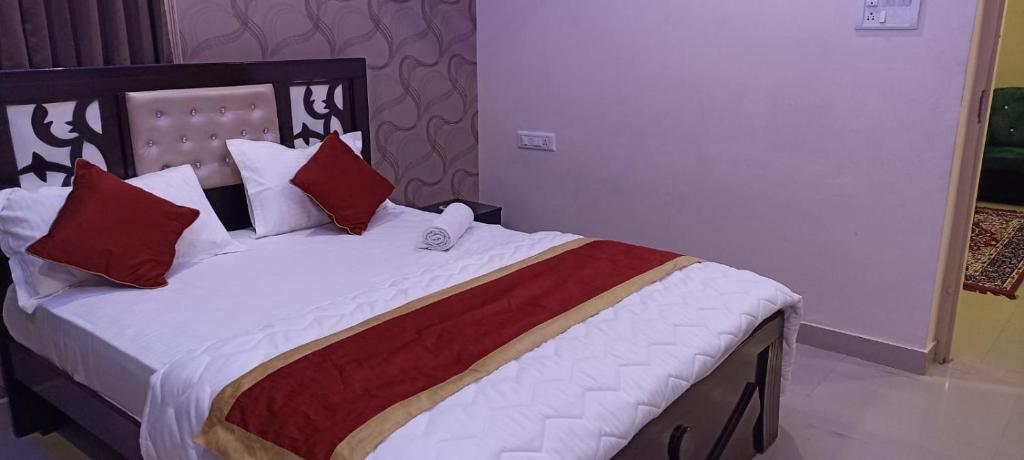 バンガロールにあるUrban Stay Adams Service Apartmentのベッドルーム1室(大型ベッド1台、赤い枕付)