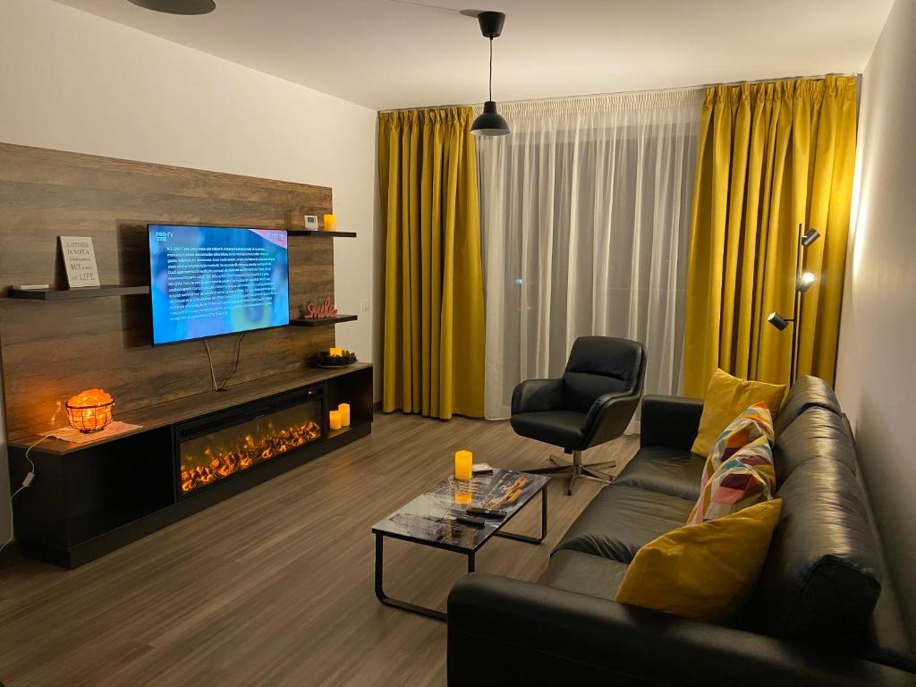 un soggiorno con divano e camino di BrasoVista - PAJ Premium Apartments in URBAN Plaza a Braşov