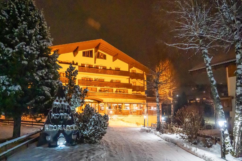 a large building in the snow at night at Park Hotel Leonardo in Moena