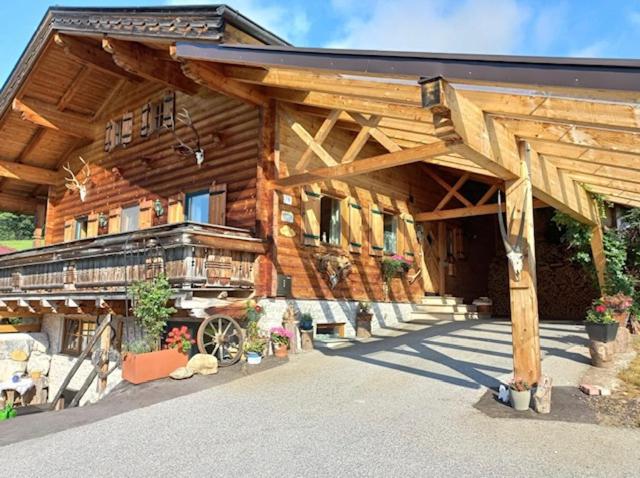 une grande maison en bois avec un grand toit dans l'établissement Haus Rosa, à Goldegg