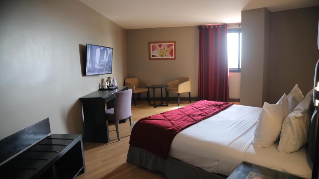 a hotel room with a bed and a desk at Liberté Hotels Oran in Oran